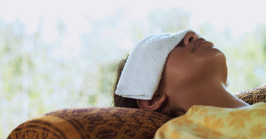 Warm compress being applied to closed eyelids for dry eye relief