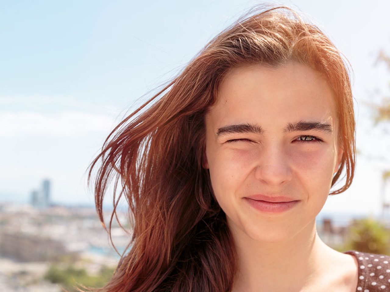 Person squinting in bright sunlight — photophobia light sensitivity